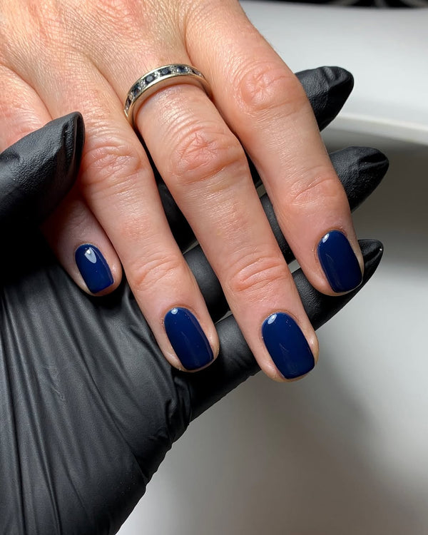 Hand with Nightingale navy blue gel nails 