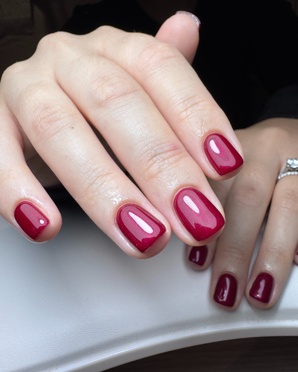 Close-up of a hand with red metallic nail gel in Carmilla from Calgel and Pro Colour