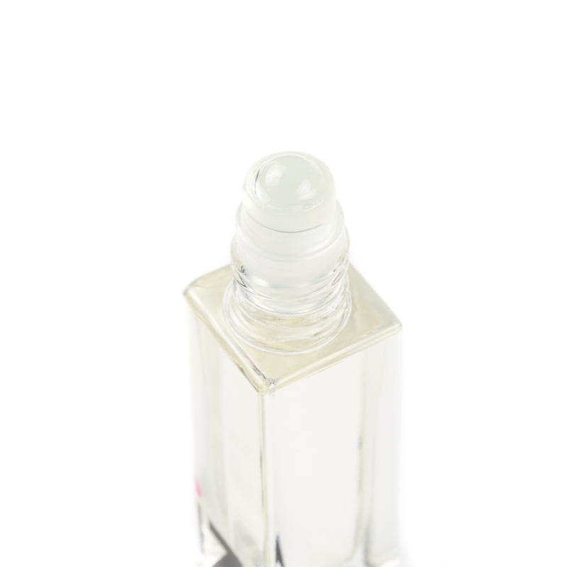 Clear glass roller bottle with a white cap on a white background filled with cuticle bottle.