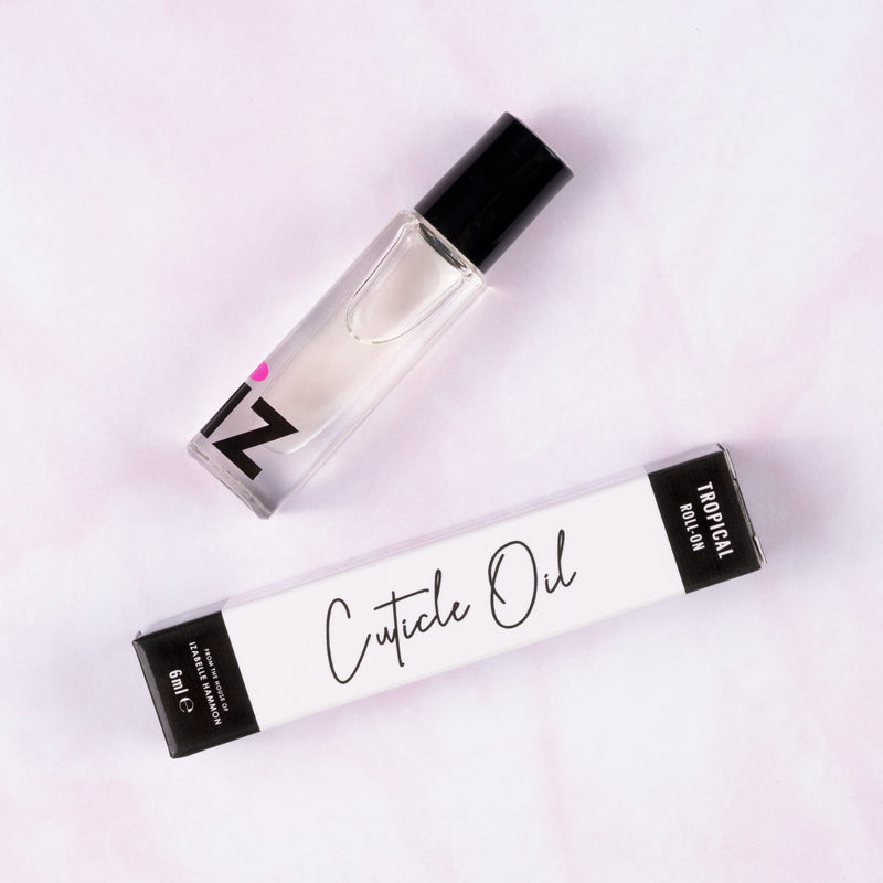 Roll on cuticle oil bottle and packaging on a light pink background