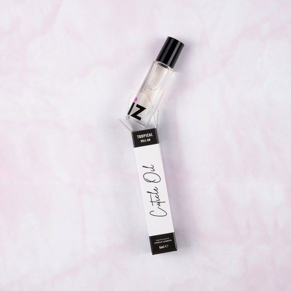 Cuticle oil roller bottle and packaging on a light pink background