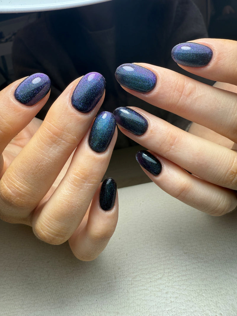 Close up of  hands wearing Holiday Haze magnetic cat eye gel from Calgel and Pro Colour. 