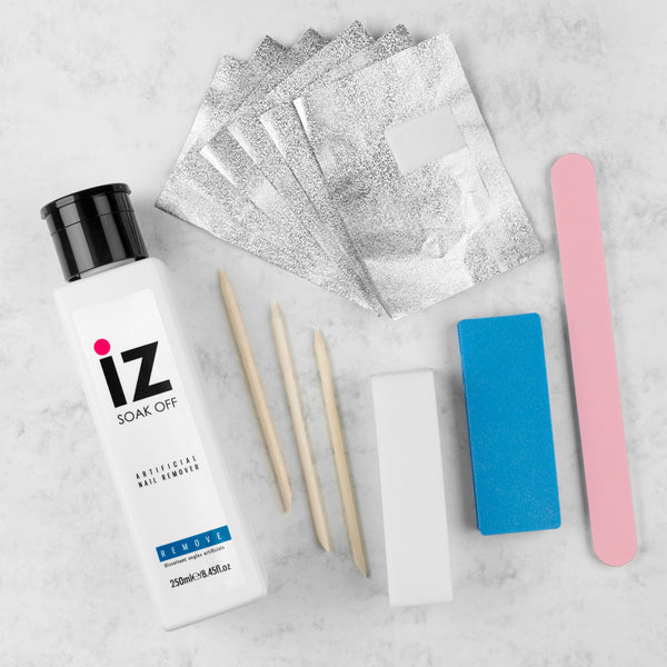 Gel soak-off kit with remover wraps, buffer block, nail file, and cuticle tool on a flatlay background.